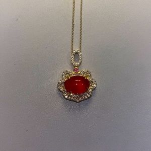 gold necklace with red pendant and diamond accents